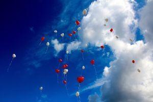 Herzluftballons, die in den Himmel fliegen stehen stellvertretend für die Träume und Visionen, die ihr im Visionsboard für eure Beziehung festshalten könnt